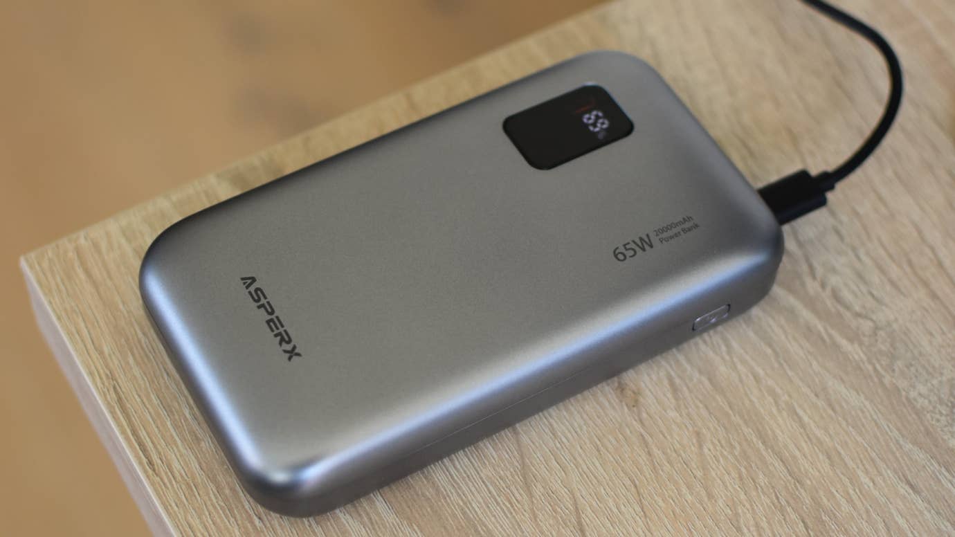 The AsperX 65W 20000mAh Power Bank on a desk.